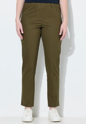 Olijfgroene, stretch katoenen broek met een platte tailleband, voorzakken en een tapered leg ontwerp. Gecombineerd met witte sneakers.