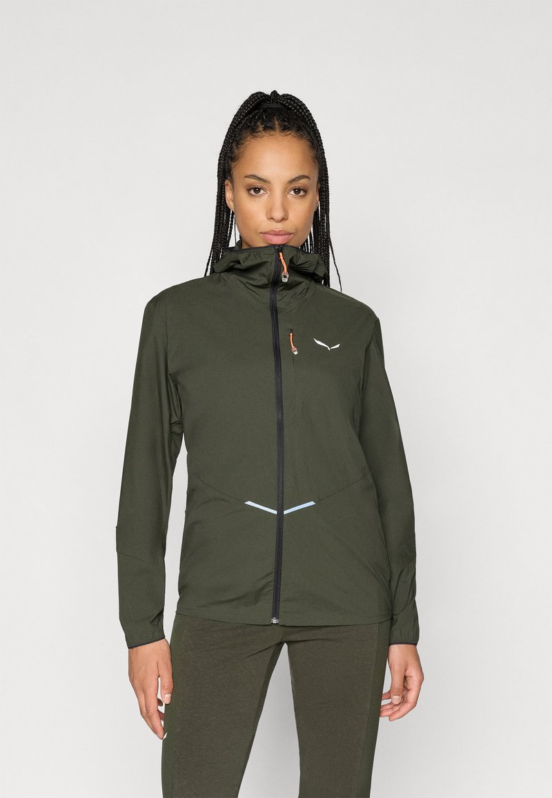 Λαδί αδιάβροχο μπουφάν με ψηλό γιακά, πλήρη φερμουάρ, μπροστινή τσέπη με φερμουάρ και ανακλαστικά στοιχεία στο στήθος και στο στρίφωμα.