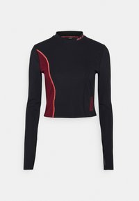 Schwarzes langärmliges Crop-Top mit Stehkragen, kontrastierenden burgunderfarbenen Seitenpanelen und dekorativen roten Nähten entlang der Kanten.