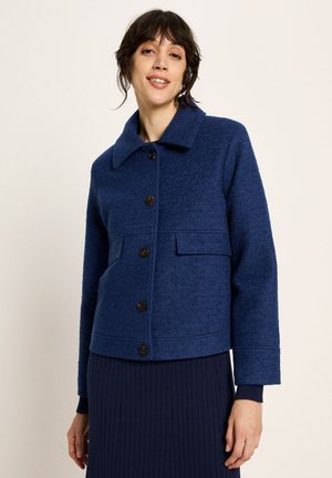 Marineblaue, verkürzte Jacke aus strukturiertem Wollmaterial, mit spitzem Kragen, Knopfverschluss und Taschen auf der Vorderseite.