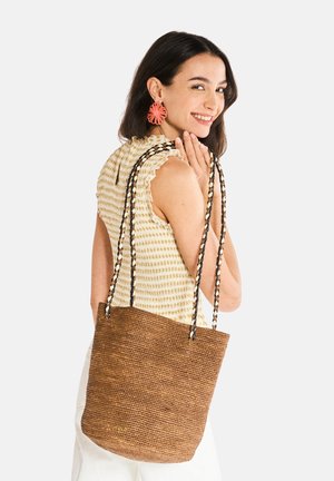Borsa tote intrecciata marrone con manici intrecciati neri e bianchi. Presenta un logo dorato alla base. La superficie textured aumenta l'interesse visivo.