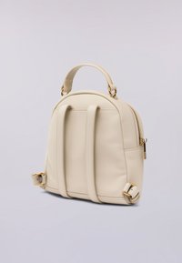 Mochila de imitación cuero beige con una parte superior redondeada, dos correas ajustables, un asa en la parte superior y detalles en tono dorado en la cremallera y hebillas.