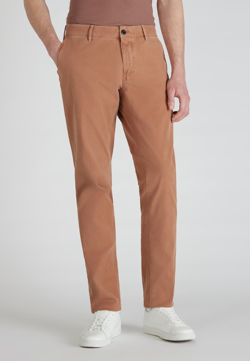Spodnie chino w kolorze rdzy, wykonane z bawełny, z prostym krojem nogawek, kieszeniami z przodu i pojedynczym zapięciem na guzik.