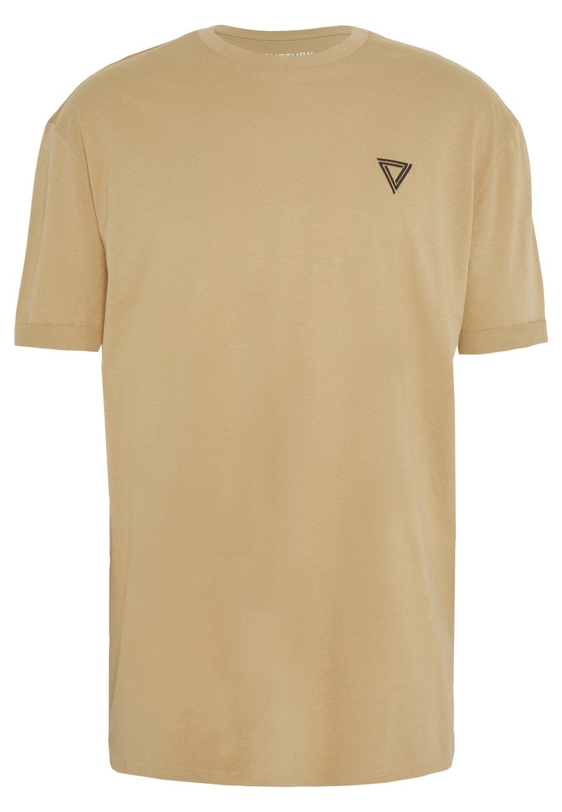 Camiseta de algodón beige con mangas cortas, escote redondo y un pequeño logo triangular negro en el lado izquierdo del pecho. Textura suave.
