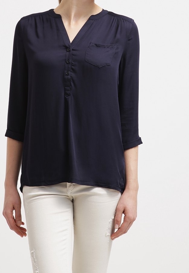 Marinblus med lätt vikt, V-ringning, knappframsida och bröstficka. Trekvartslånga ärmar med uppvikta manschetter; mjukt material.