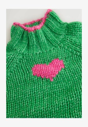 Grün gestricktes Kleidungsstück mit hohem Kragen, das ein pinkfarbenes Herzmuster auf der Vorderseite aufweist. Die Textur ist gerippt und grob, mit kontrastierenden Farben.