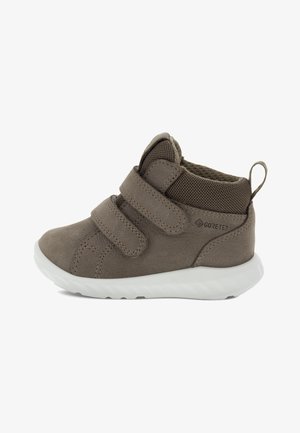 Braunes Wildleder-Kinderschuh mit zwei Klettverschluss-Riemen. Mesh-Futter und gepolsterte Sohle. Hat eine strukturierte Oberfläche und eine kleine Schlaufe an der Ferse.