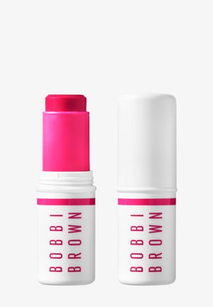 Stick baume à lèvres Bobbi Brown rose vif avec capuchon blanc et contenant affichant le nom de la marque en texte rose sur fond blanc.