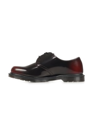 Glänzender schwarz-dunkelroter Lederschuh mit niedrigem Absatz, Schnürung vorne und dicker schwarzer Gummisohle auf weißem Hintergrund.