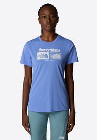 Light blue short-sleeve t-shirt featuring a white graphic logo and text on the front. Smooth fabric, round neckline, relaxed fit.