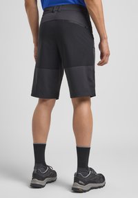 Shorts neri in tessuto elasticizzato con un pannello testurizzato a contrasto. Dotati di una tasca con zip sul retro e di una vita con passanti per cintura.