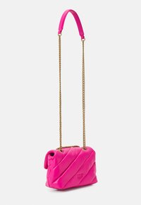 Bolso de mano de cuero acolchado rosa con una cadena y una correa de cuero, con costuras diagonales y un pequeño logotipo en la parte frontal.