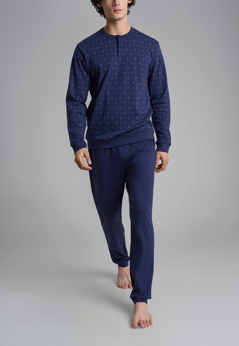Set da loungewear blu navy composto da un top a maniche lunghe con motivo e bottoni, abbinato a pantaloni con vita elastica, realizzati in un tessuto morbido.