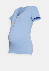 Blusa de maternidade ajustada, de cor azul claro, com tecido texturizado, mangas curtas, decote em V e fechamento de cinco botões na frente.