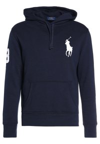 Námořnická modrá mikina s kapucí a přední kapsou, se stahovací šňůrkou na kapuci, bílým logem polo hráče na hrudi a bílou nášivkou čísla 3 na pravém rukávu.