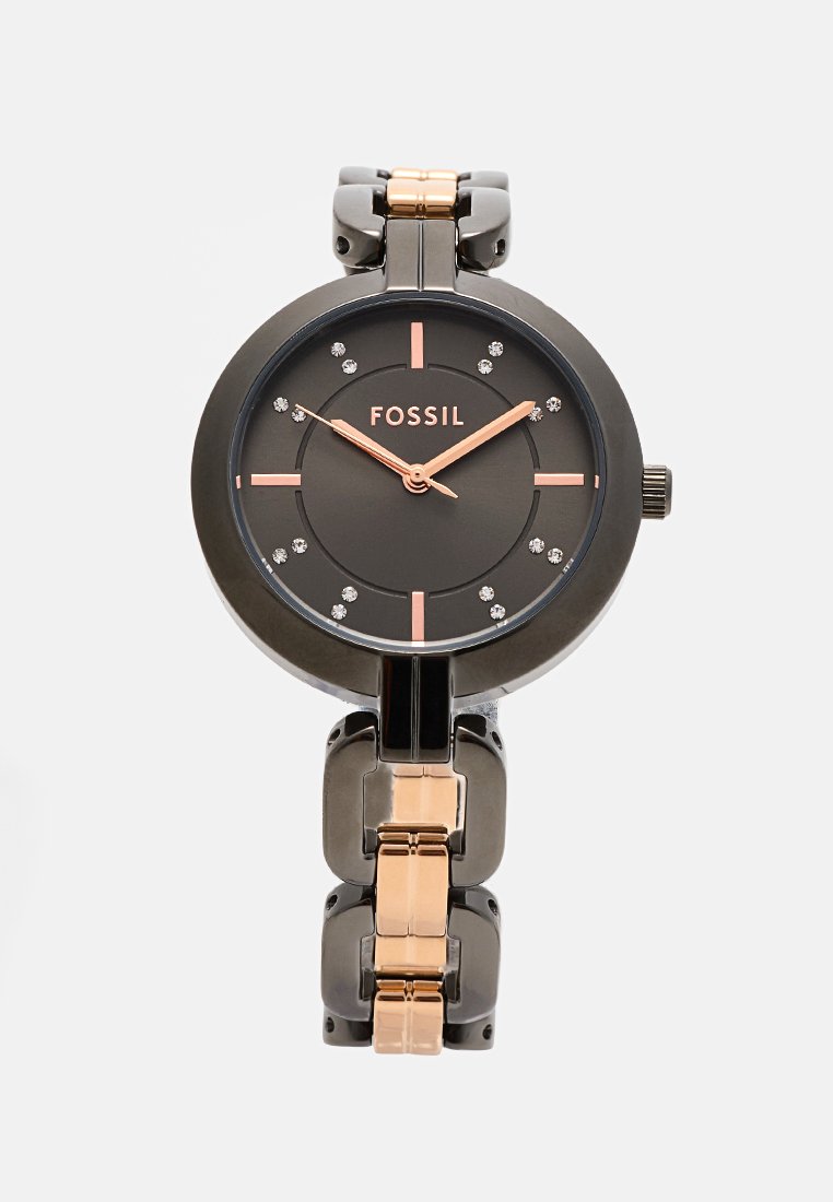Montre femme Fossil avec un boîtier en métal noir, un cadran sombre, des accents en or rose, des index en cristal et un bracelet articulé comportant des sections en or rose et noir.