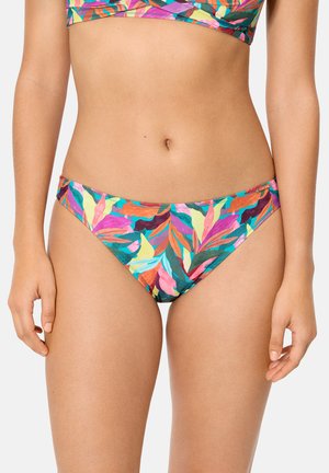 Mujer con bikini de colores con estampado de hojas y top a juego, de pie con los brazos relajados a los lados contra un fondo liso.