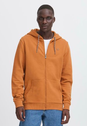 Oranje zip-up hoodie met koord, voorzakken en ribgebreide manchetten. Zachte stofstructuur, met een subtiele logo op de borst.
