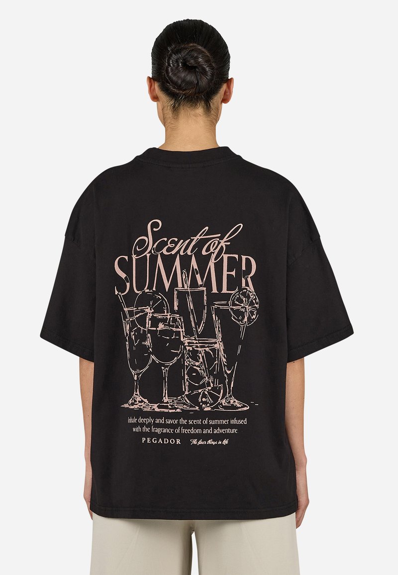 Black oversized t-shirt featuring a pink graphic of cocktails and text "Scent of Summer" on the back. Soft fabric, short sleeves, relaxed fit.