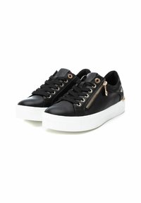 Zapatillas de cuero negro con suelas de goma blancas, que presentan ojales en tono dorado, un detalle de cremallera en el lateral y acentos texturizados en la lengüeta.