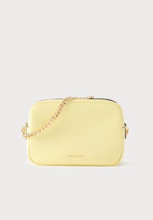 Small rectangular pale yellow leather crossbody bag with gold chain strap and Michael Kors logo on front.