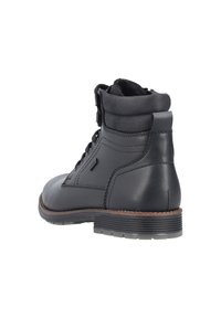 Botín negro de cuero con un acabado suave. Presenta un diseño de cordones, cuello acolchado y una suela de goma texturizada.