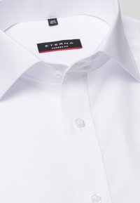 Hvid skjorte med spread krave, med en klar knapstolpe og ETERNA mærket. Moderne pasform og glat bomuldsstruktur.