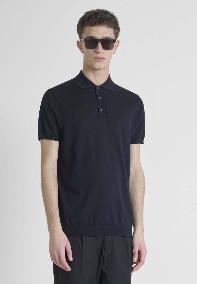 Navy korte mouwen polo shirt van een zachte gebreide stof met een knoopsluiting, geribde manchetten en een subtiele logo op de borst.