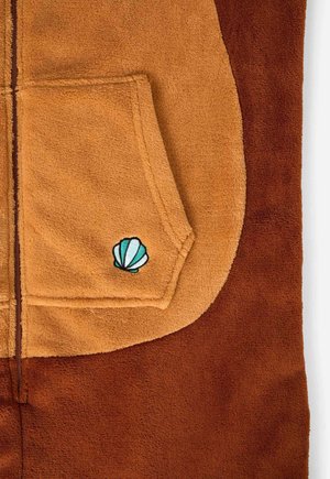 Rjav in bež flis oblačilo z žepom spredaj, ki ima svetlo moder vezeninasti školjčni motiv. Mehka tekstura in kontrastne barve.