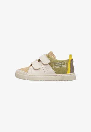 Beige en groene kindersneaker met dubbele witte klittenbandsluitingen, gele hieltab en tekst "Naturino 74 The Original Brand" aan de zijkant.