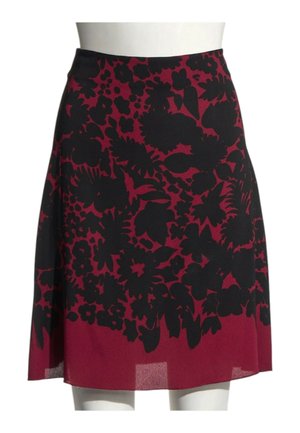 Jupe rouge longueur genou avec motif floral noir exposée sur un buste de mannequin blanc.