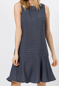Ärmelloses navyblaues Kleid mit geometrischem Muster, ausgestelltem Saum und strukturierter Stoffqualität. Es hat einen runden Ausschnitt und eine lässige Passform.