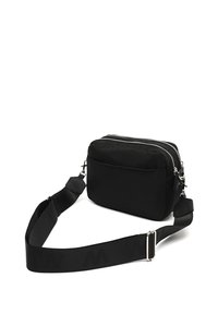Borsa a tracolla nera realizzata in tessuto morbido, dotata di due scomparti con zip, una tasca frontale e una spallina regolabile spessa con motivo del logo.