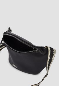 Czarna skórzana torebka na zamek błyskawiczny, z fakturowaną powierzchnią i wzorzystym paskiem z czarnymi i białymi akcentami.