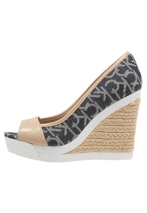 Sandale compensée bleu marine et beige avec semelle intermédiaire en jute tissée, bout ouvert et dessus en tissu à motifs.