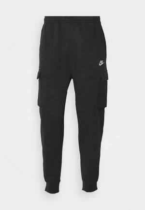 Pantalones cargo negros de felpa con cintura elástica, bolsillos laterales y un pequeño logotipo blanco de Nike en el muslo izquierdo. Textura de tela suave.