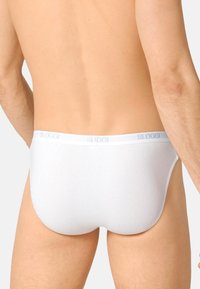 Weiße Unterhosen mit einer weichen Textur, SLOGGI-Logo am elastischen Bund, tief geschnittenes Design und nahtloser Rückseite. Einfach und funktional.