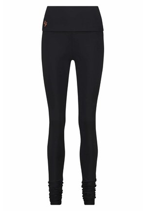 Schwarze Leggings mit einem breiten Bund, dehnbarem Material und gerafften Knöcheldetails. Glatte Textur mit dezentem Logo am Bund.