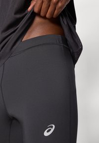 Μαύρα αθλητικά κολάν με λεία υφή, χαρακτηριστικά ασημί λογότυπο, ψηλή μέση και  επίπεδες ραφές για άνεση και ευκαμψία.