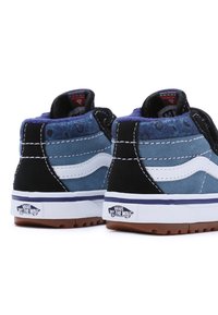 Baskets montantes en suède et toile bleu, noir et blanc ; coutures blanches ; semelle en caoutchouc ; logo "Off the Wall" sur le talon.