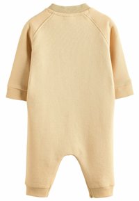 Beige Baumwoll-Jumpsuit mit langen Raglansärmeln, geripptem Halsausschnitt und Bündchen sowie einem lockeren Schnitt. Weiche Textur, schlichtes Design, keine Muster.