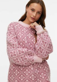 Pull-over en tricot rose avec un motif en diamant complexe, col rond et coupe ample. Texture douce avec des poignets côtelés.