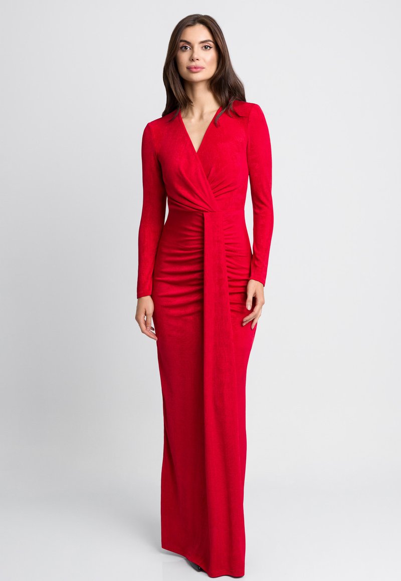 Czerwona sukienka z długim rękawem i dekoltem w kształcie litery V, z materiałem drapowanym, podąłem po bokach i prostą sylwetką. Miękka, gładka tekstura.