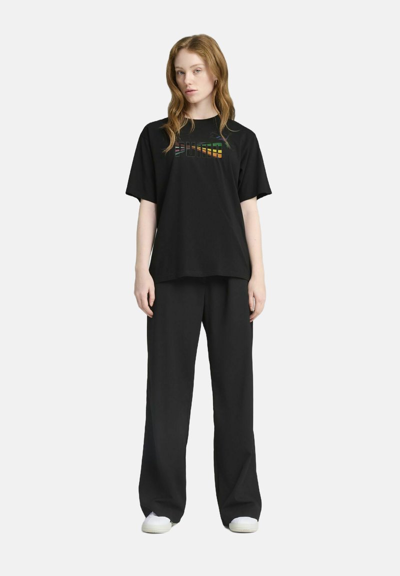 Sort t-shirt og vide bukser sæt. T-shirten har et multicolor "PUMA" logo på brystet. Glat stof, afslappet pasform.