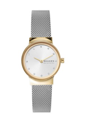 Okrągły zegarek w złotym odcieniu z srebrną siateczkową bransoletą, minimalistyczna biała tarcza z kryształowymi znacznikami godzin i złotymi wskazówkami, widoczne logo Skagen Denmark.