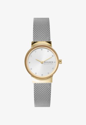 Reloj redondo en tono dorado con correa de malla plateada, esfera blanca minimalista con marcadores de hora de cristal y agujas doradas, logo de Skagen Denmark visible.
