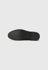 Sort skosål med glat gummioverflade, afrundet form og minimal syning langs kanten. Flad design uden mønstre.