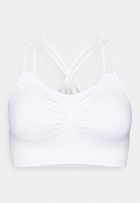 Soutien-gorge de sport blanc avec une texture lisse, doté d'un design froncé à l'avant et de bretelles croisées à l'arrière. Fabriqué en matière extensible.