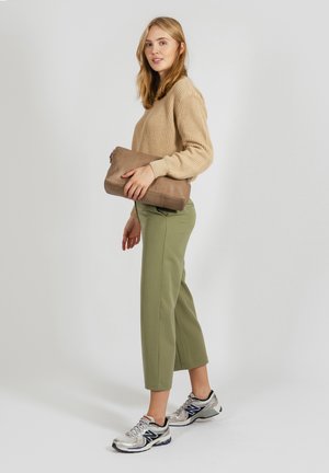 Beige ribbed sweater, olive green cropped trousers, silver athletic shoes, and a brown clutch. Simple design with textured fabrics.