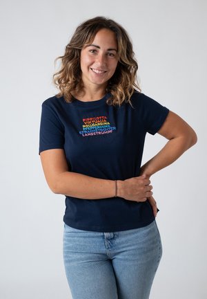 Navy cotton t-shirt featuring colorful text in a stacked layout. Short sleeves with a relaxed fit, paired with light blue jeans.